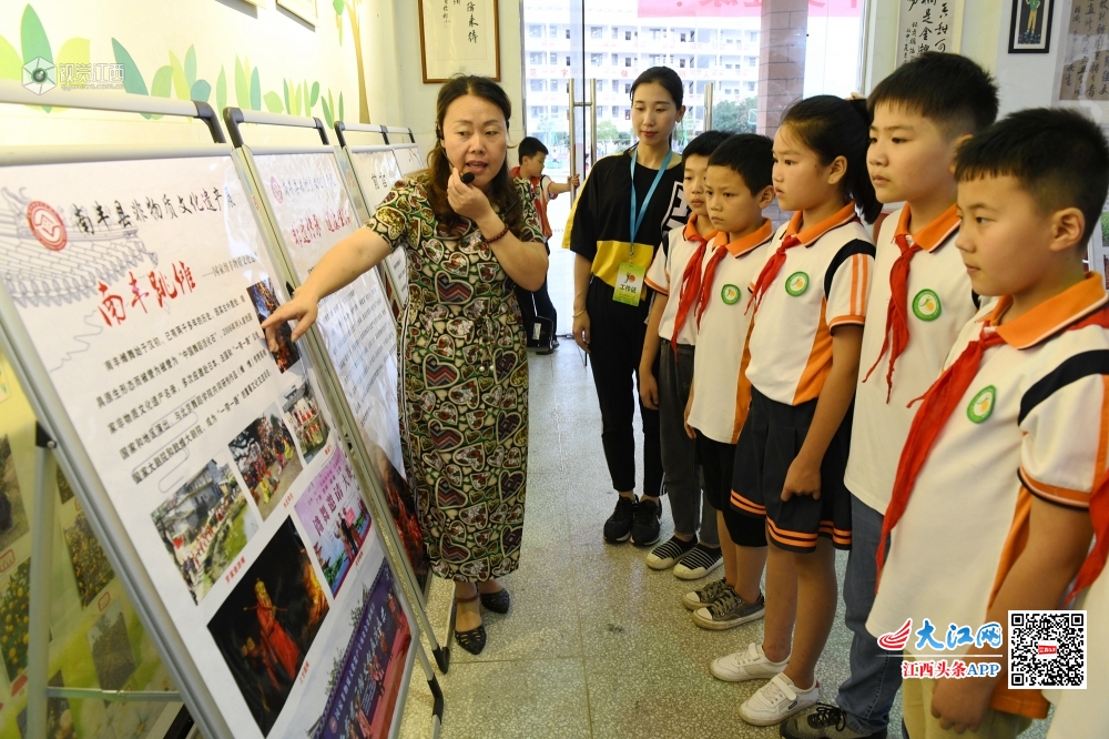 2020年6月11日，民间艺人正在为江西省抚州市南丰县桔都小学学生展示南丰傩面具雕刻技艺。