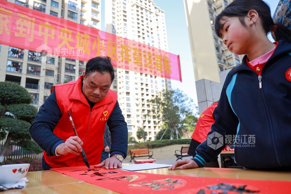 2025年1月16日，江西省吉安市吉水县东山中央城小区，文艺志愿者正在为居民书写春联和“福”字。