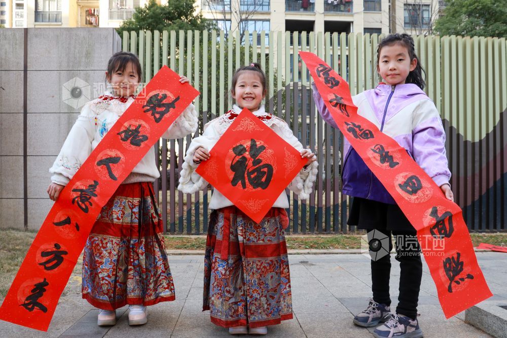 2025年1月16日，江西省吉安市吉水县东山中央城小区，文艺志愿者正在为居民书写春联和“福”字。