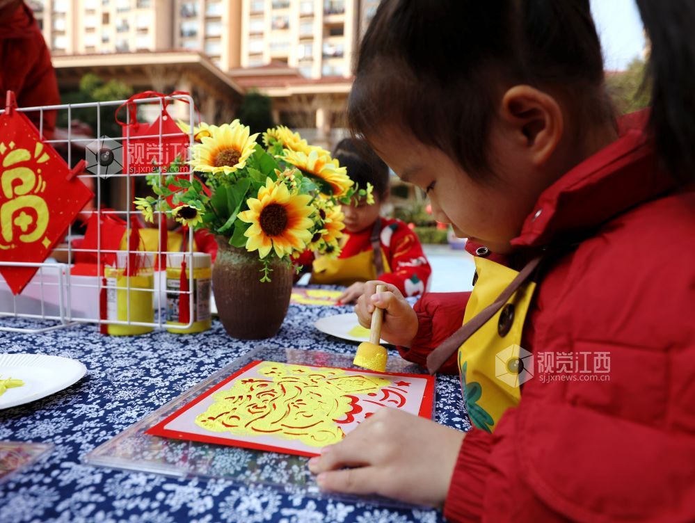 孩子们展示自己拓印好的“福”字图案迎接新春。